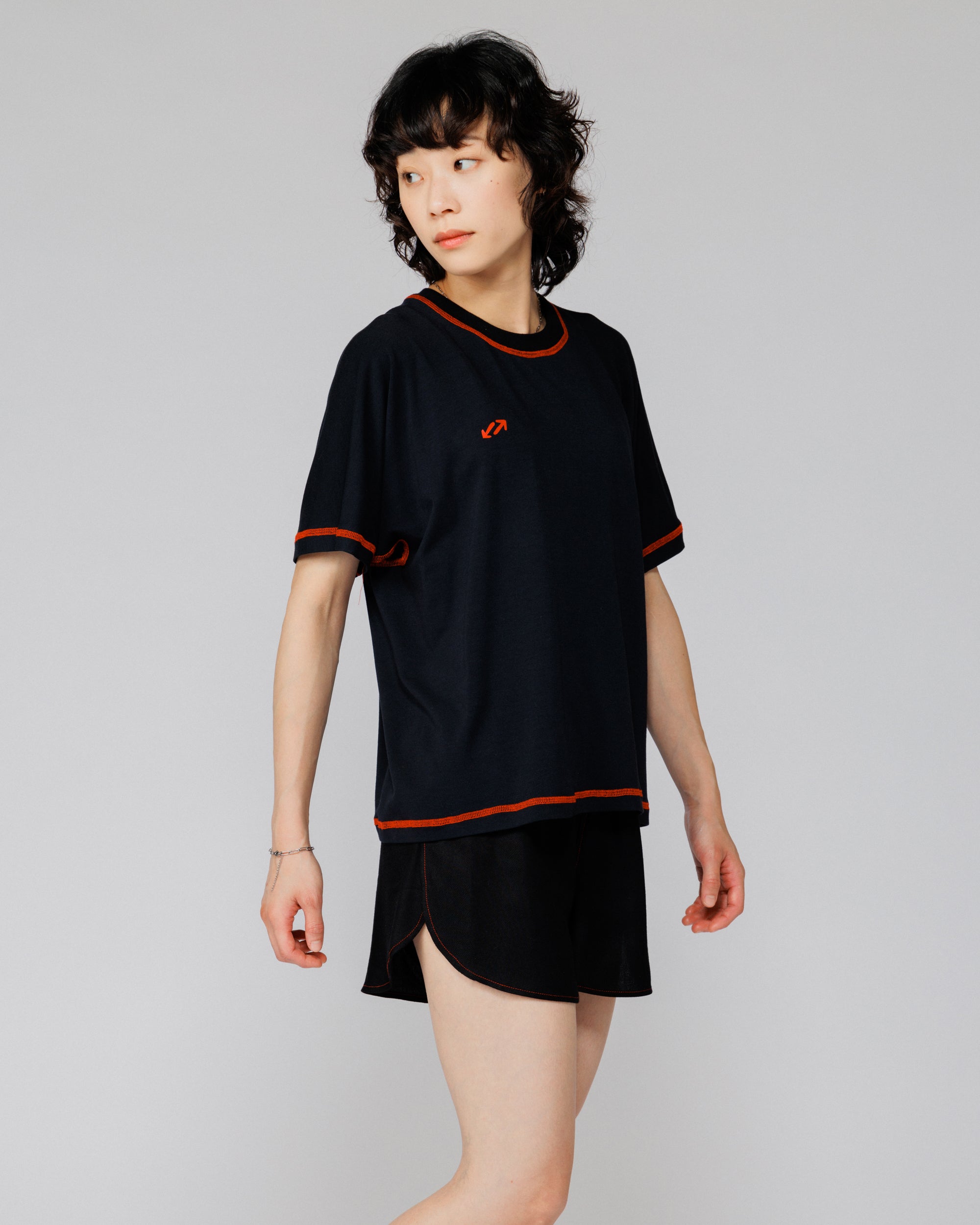 Model wearing Outnback Bog Tee in black, three-quarter front view turning