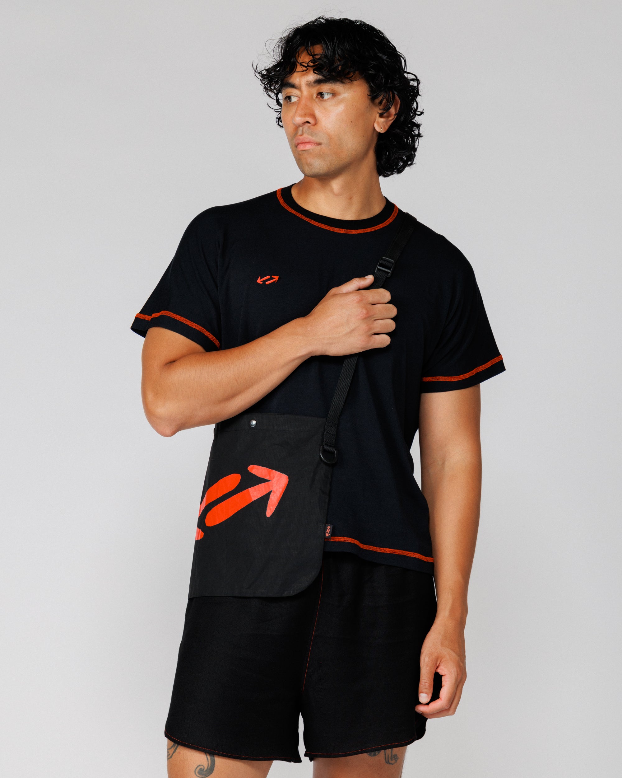 Outnback Musette in black worn crossbody, model holding the webbing strap
