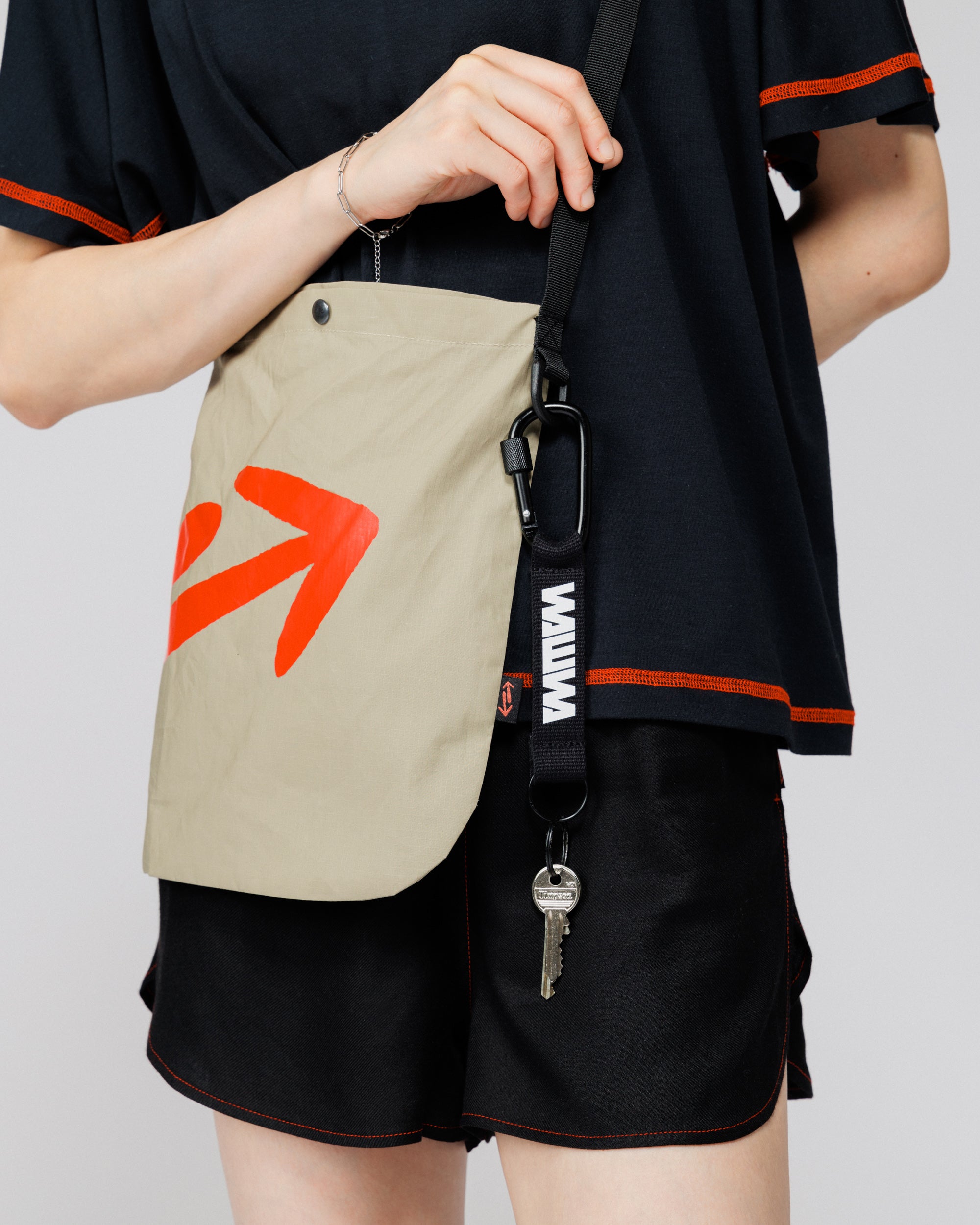 Outnback Musette in stone in use, close crop of strap carabiner and WAWWA key clip