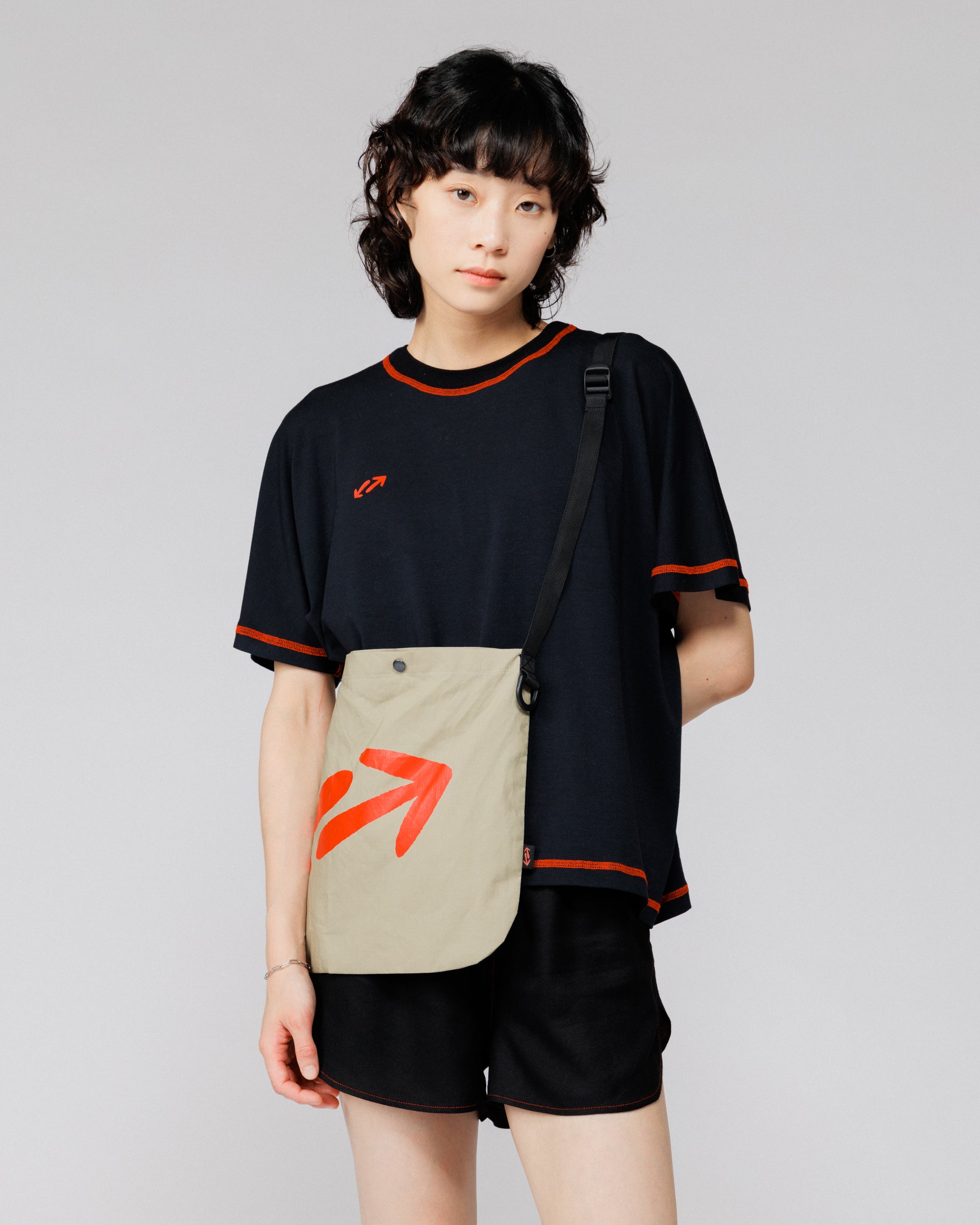 Outnback Musette in stone worn crossbody, cropped front view showing bag scale at the hip