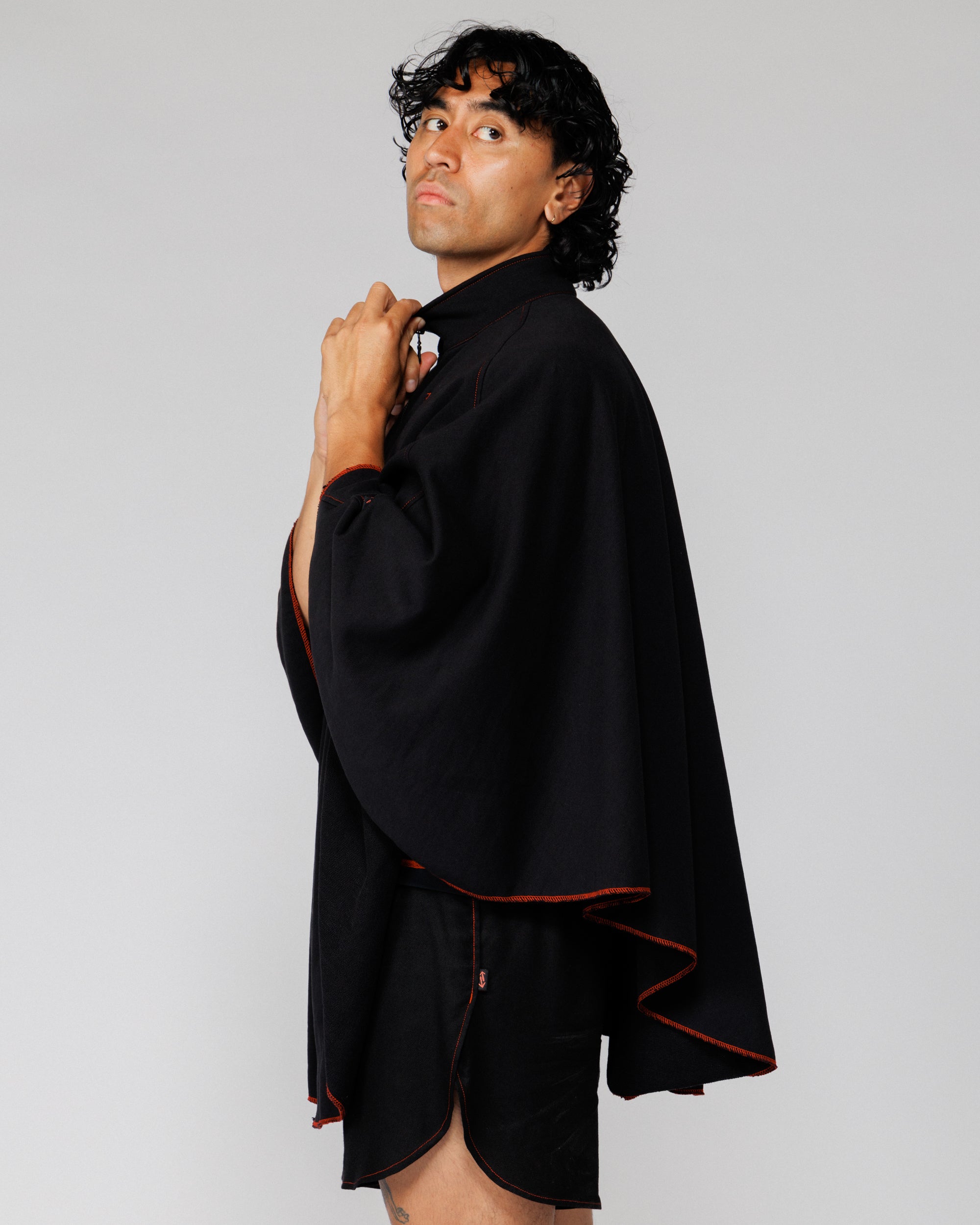 Outnback Recovery Cape in black worn by model, cropped side profile view