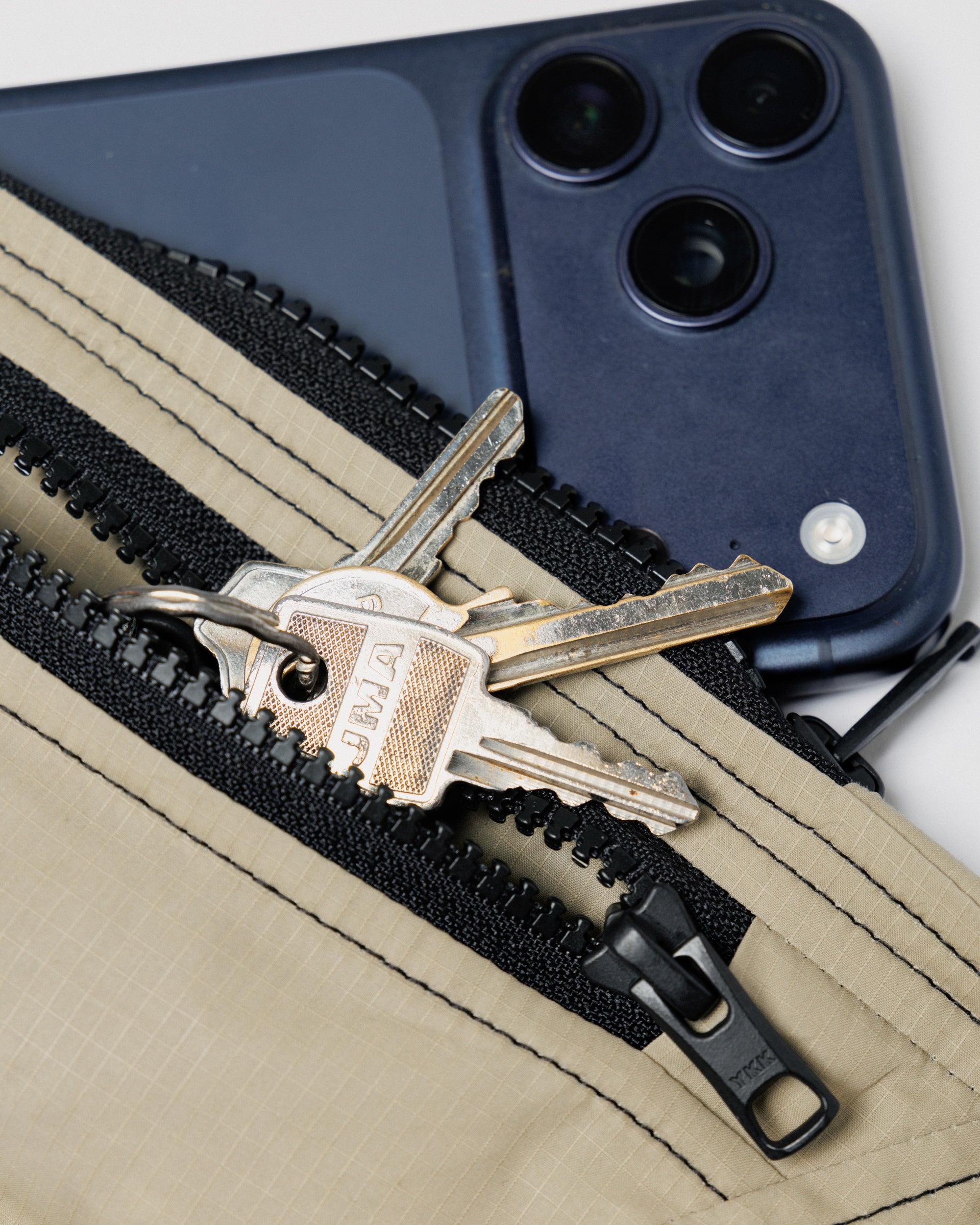 Outnback Running Strap in stone, in use holding a phone and keys