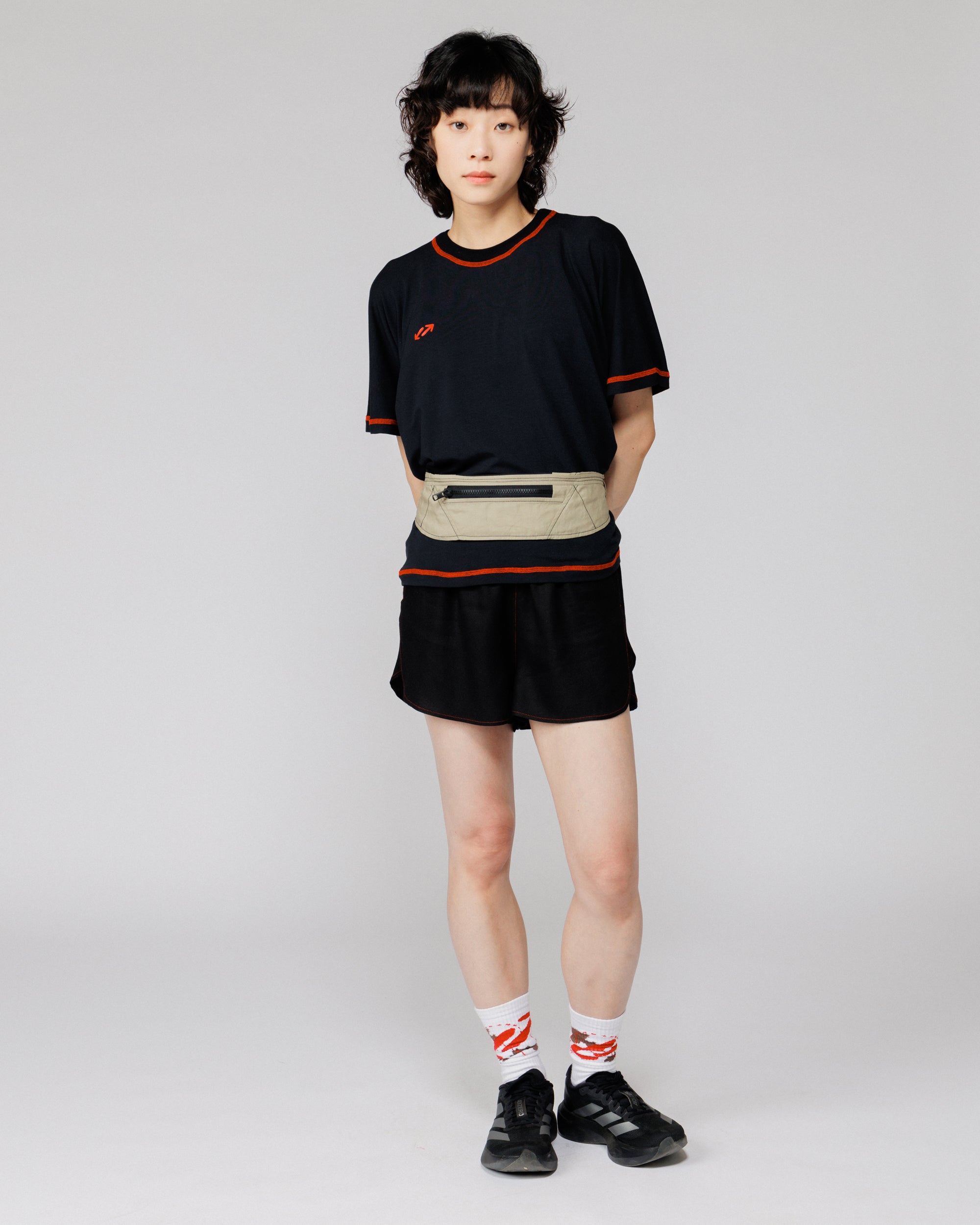 Outnback Running Strap in stone worn at the waist, full-length front view on model