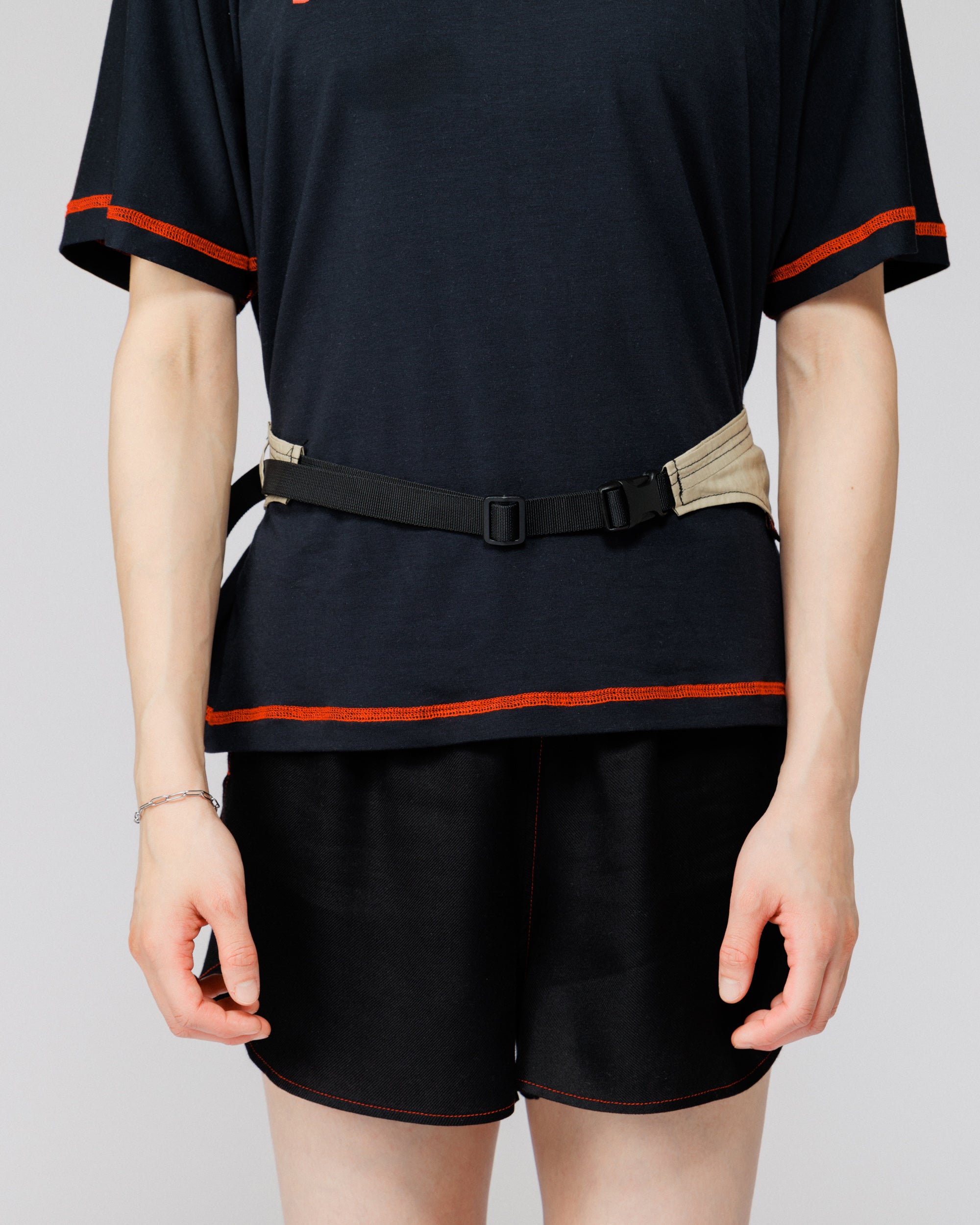 Outnback Running Strap in stone worn at the waist, webbing belt and buckle across the front