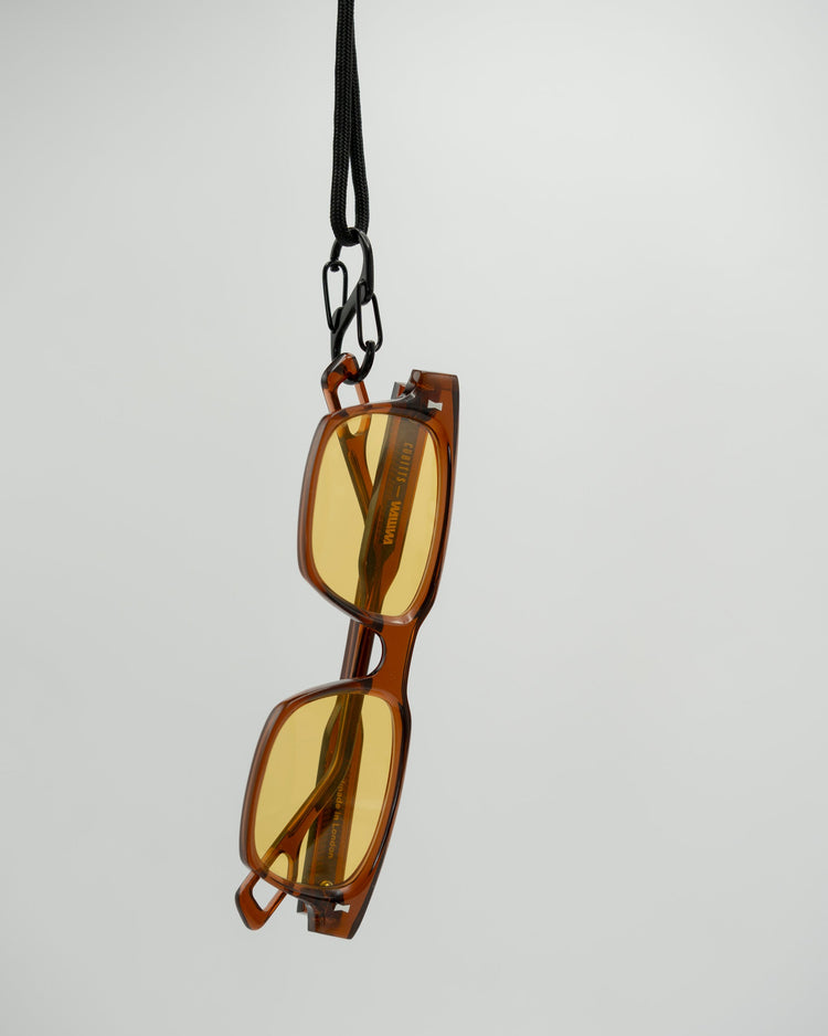 Solaris Sunglasses in coconut hanging from paracord neck strap, Cubitts x WAWWA engraving on temple