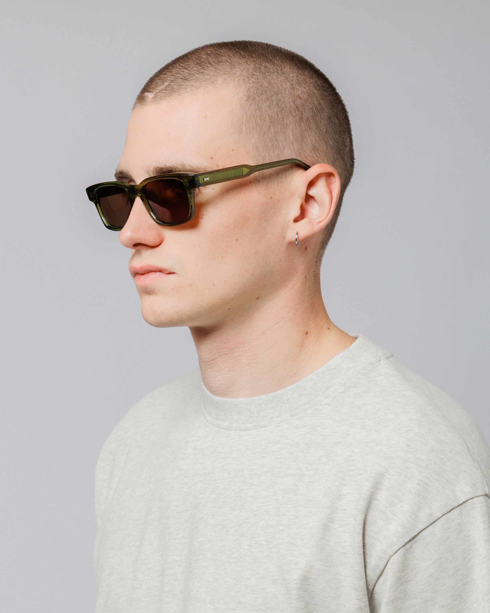 Male model wearing Solaris Sunglasses in khaki, three-quarter view