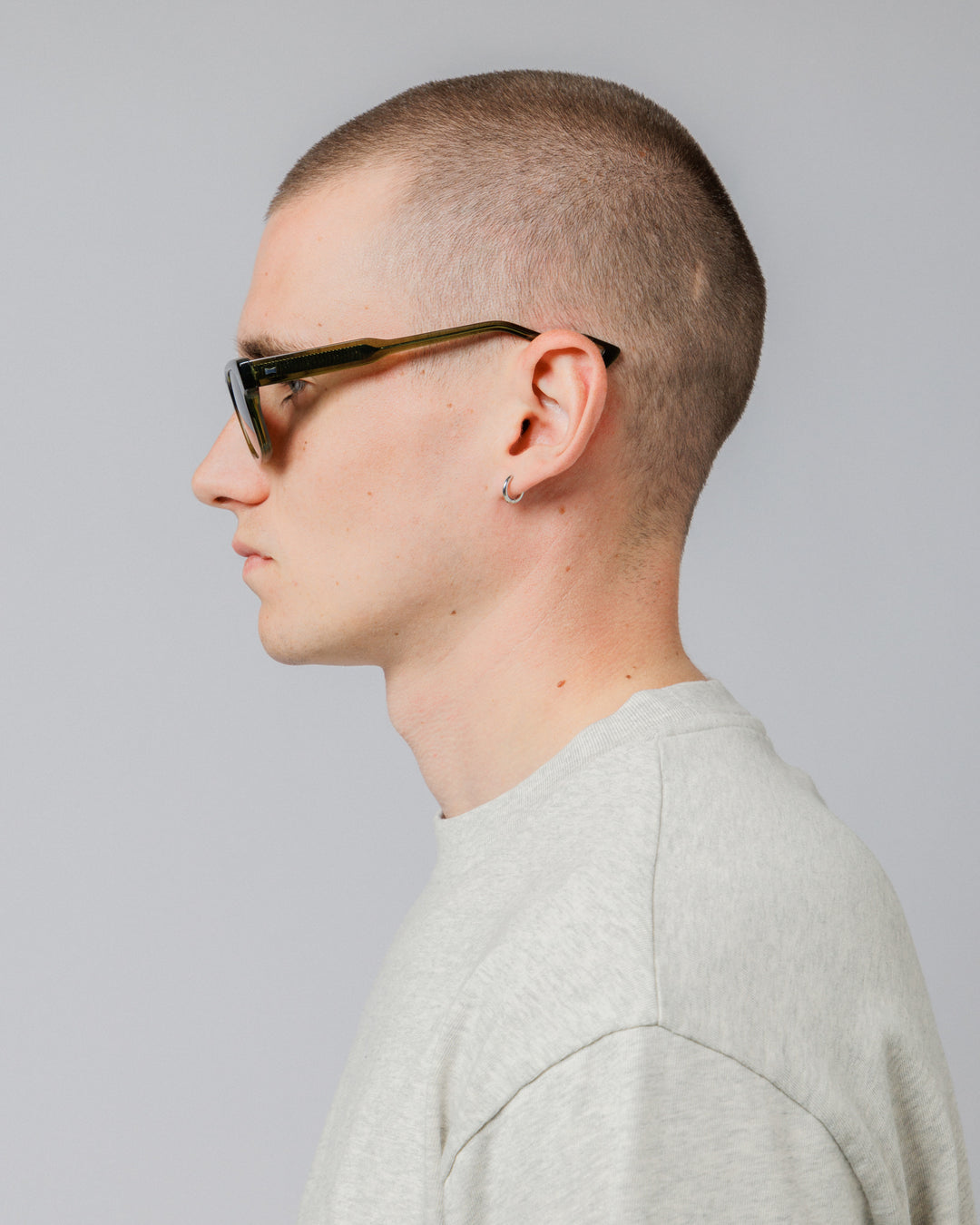 Male model wearing Solaris Sunglasses in khaki, side profile showing temple arm
