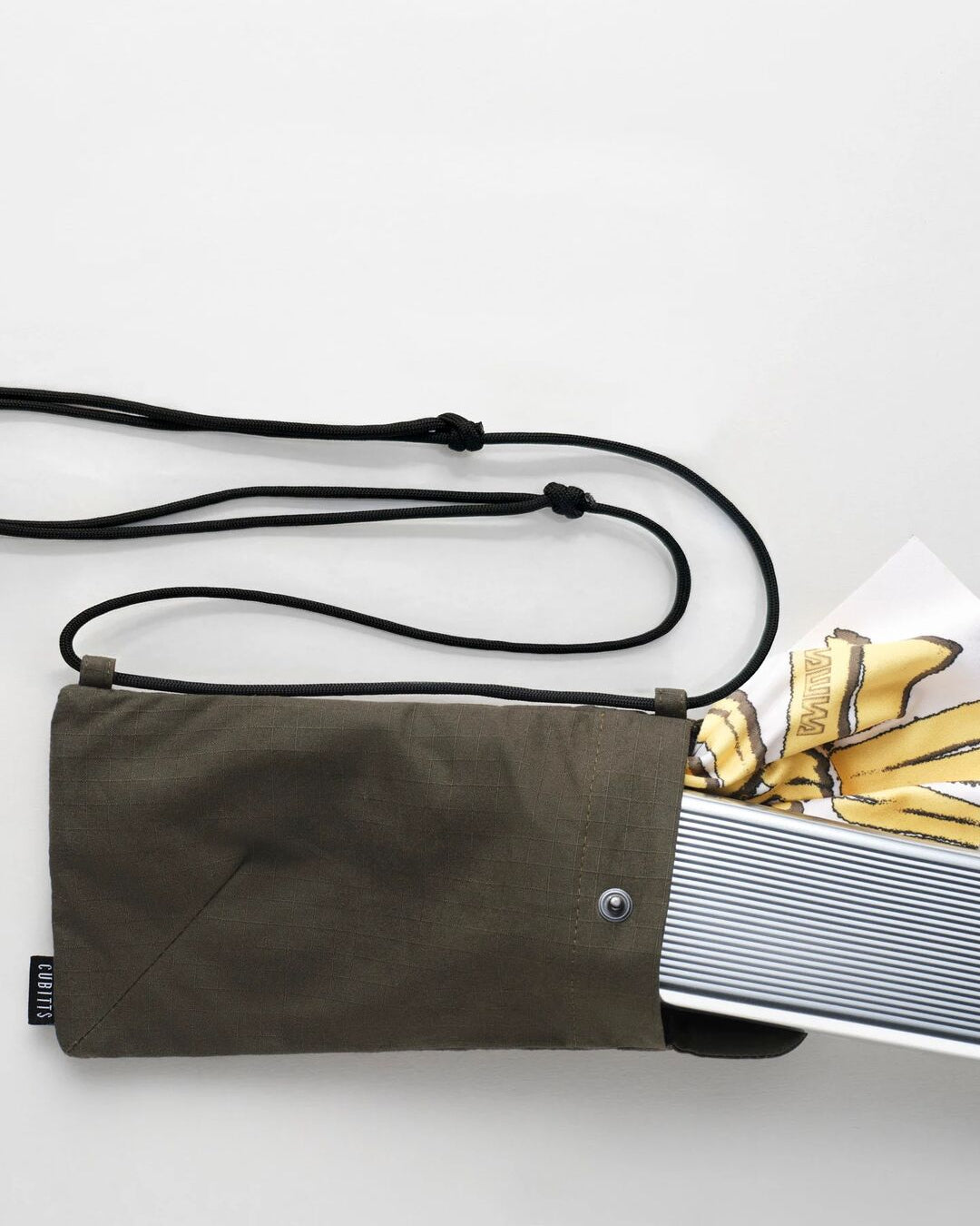 Khaki Sunnies Sling holding a tin and lens cloth, showing capacity